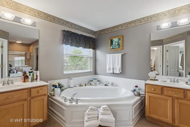 a spacious bathroom with a tub sink and mirror