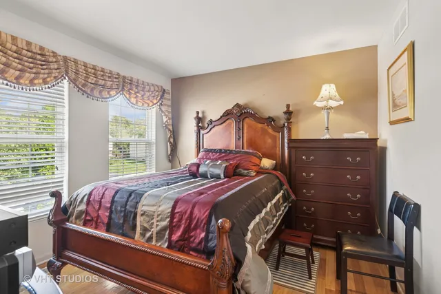 a bedroom with a bed and dresser with mirror