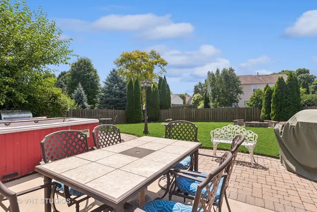 a view of a patio with table and chairs with wooden floor and fence