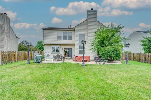 a view of a house with a yard and sitting area