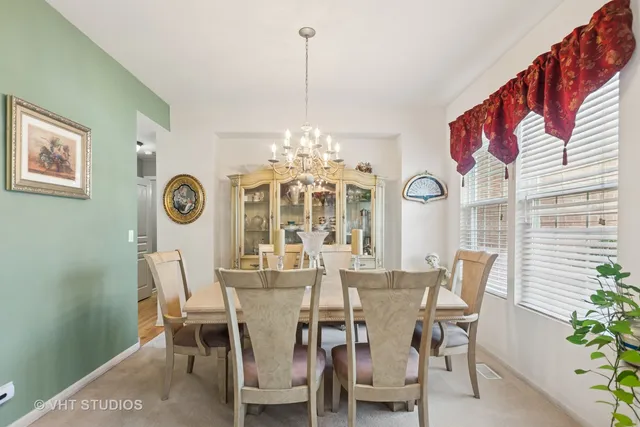 a view of a dining room with furniture and a chandelier