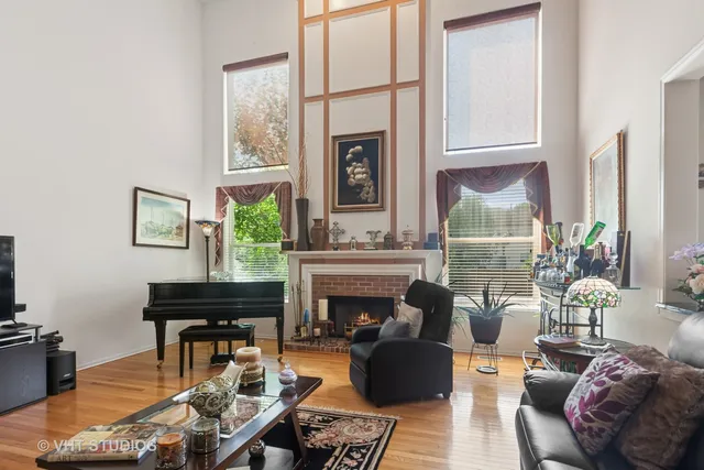a living room with furniture a fireplace and a large window