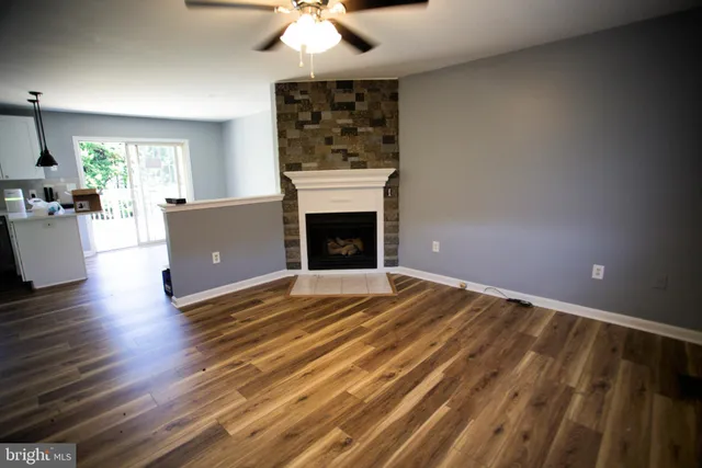 a view of empty room with wooden floor fireplace and window