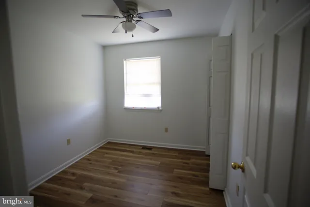 a view of room with hardwood floor and fan