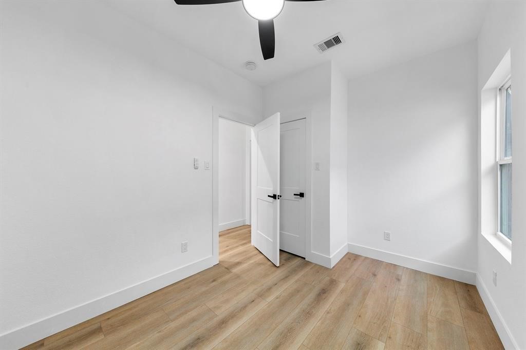 2805 Nettleton Street Houston, TX 77004 - Photo 9 of 9 This room features bright white walls, light wood flooring, a ceiling fan, and ample natural light from a large window, creating a fresh and inviting space.
