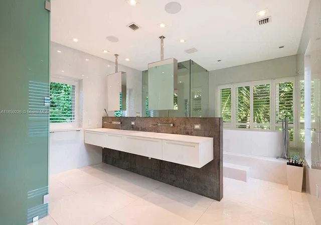 a bathroom with a large tub sink and large mirror
