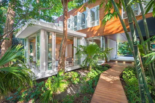 a front view of a house with a yard and potted plants
