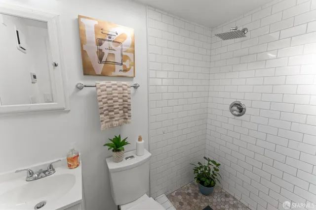 a bathroom with a sink a toilet and shower