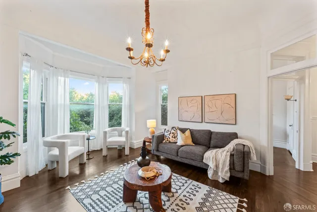 a living room with furniture a table and a chandelier