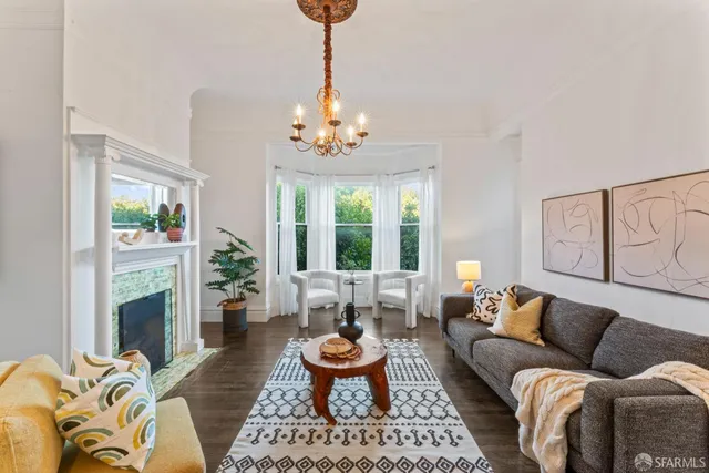 a living room with furniture chandelier and a fireplace