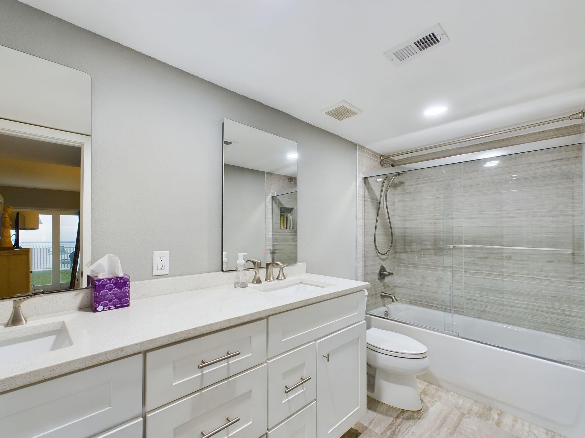 151 Calhoun Avenue, Unit 108 Destin, FL 32541 - Photo 13 of 30 a bathroom with a shower sink vanity mirror and toilet