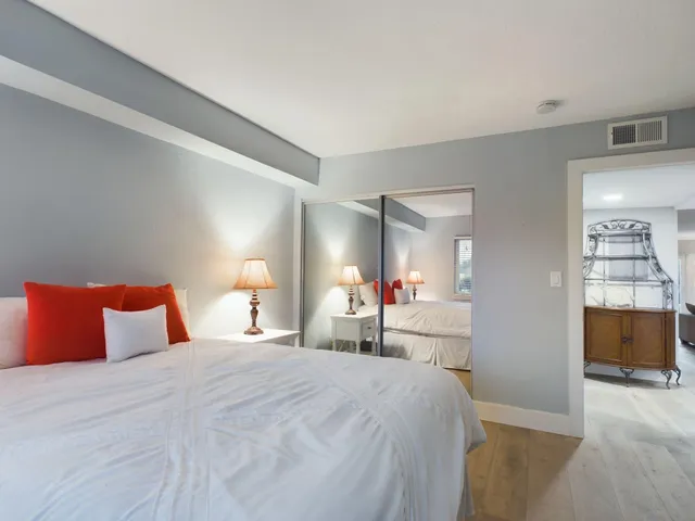 a bedroom with a bed and a large mirror