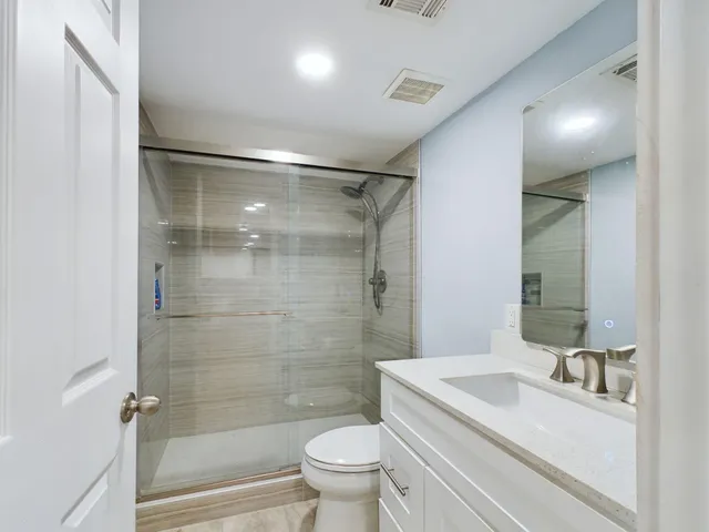 a bathroom with a sink a toilet and shower