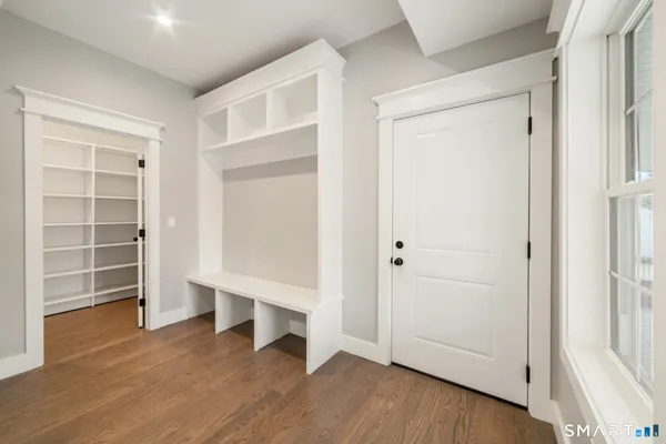 an empty room with wooden floor cabinet and window