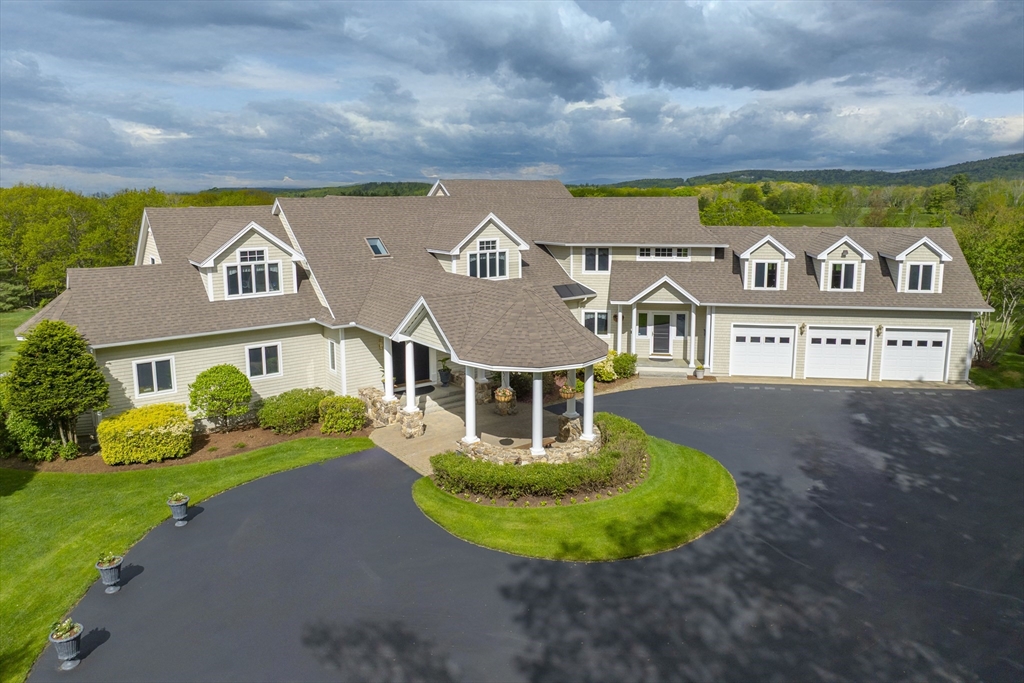 a view of a white house with a big yard and large trees