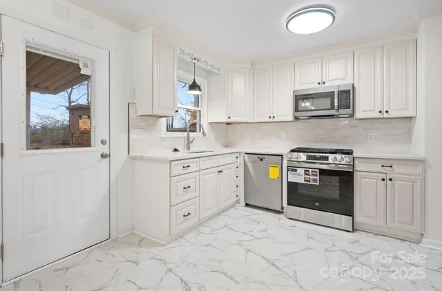 a kitchen with stainless steel appliances granite countertop a stove a sink and a refrigerator