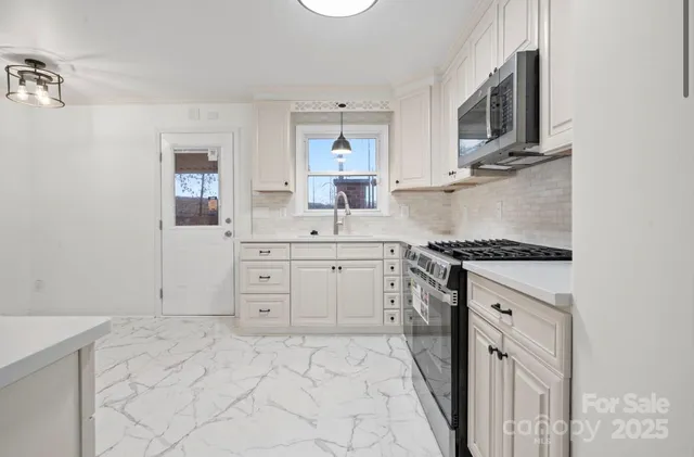 a kitchen with stainless steel appliances cabinets and a window