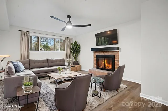 a living room with furniture a flat screen tv and a fireplace