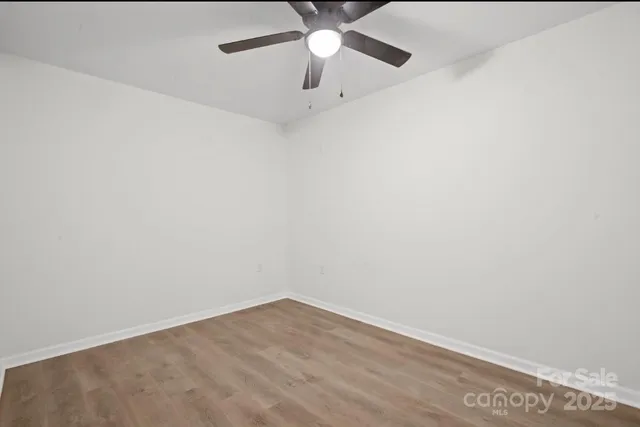 an empty room with a ceiling fan and carpet