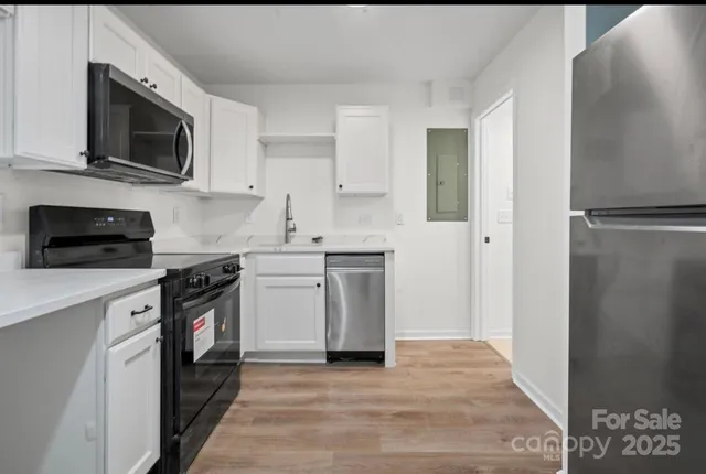 a kitchen with stainless steel appliances a white stove top oven and cabinets
