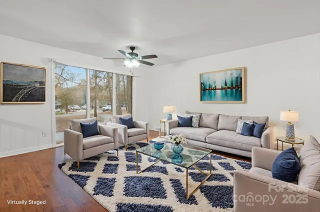 a living room with furniture a rug and a large window