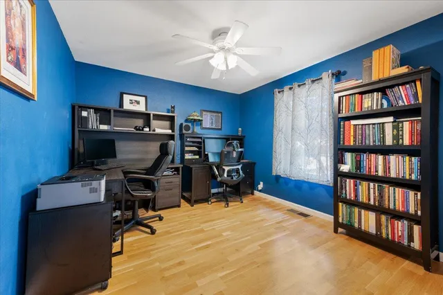 a view of an empty room with wooden floor and windows