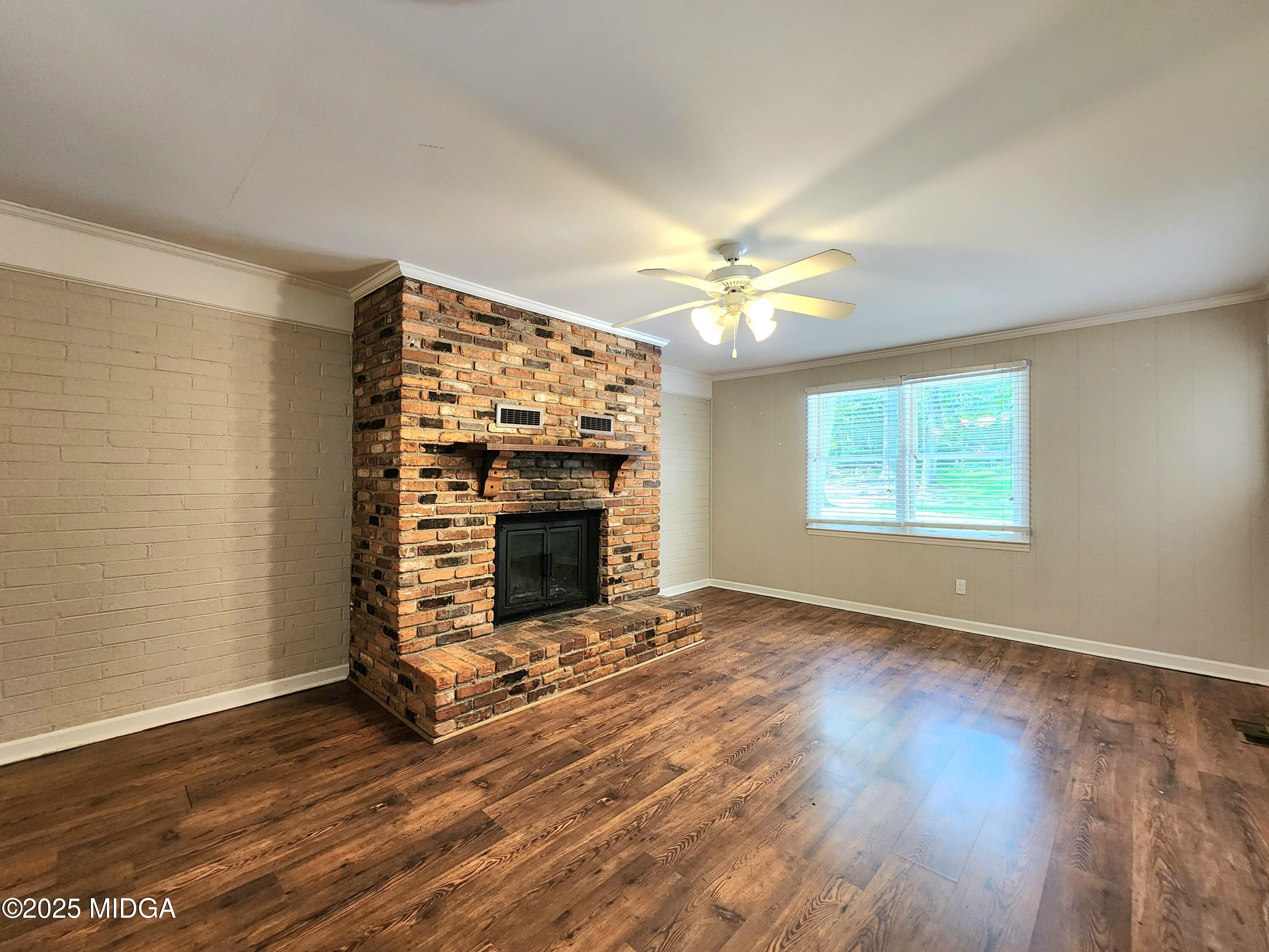 807 Wera Place Macon, GA 31210 - Photo 20 of 42 an empty room with windows fireplace and wooden floor