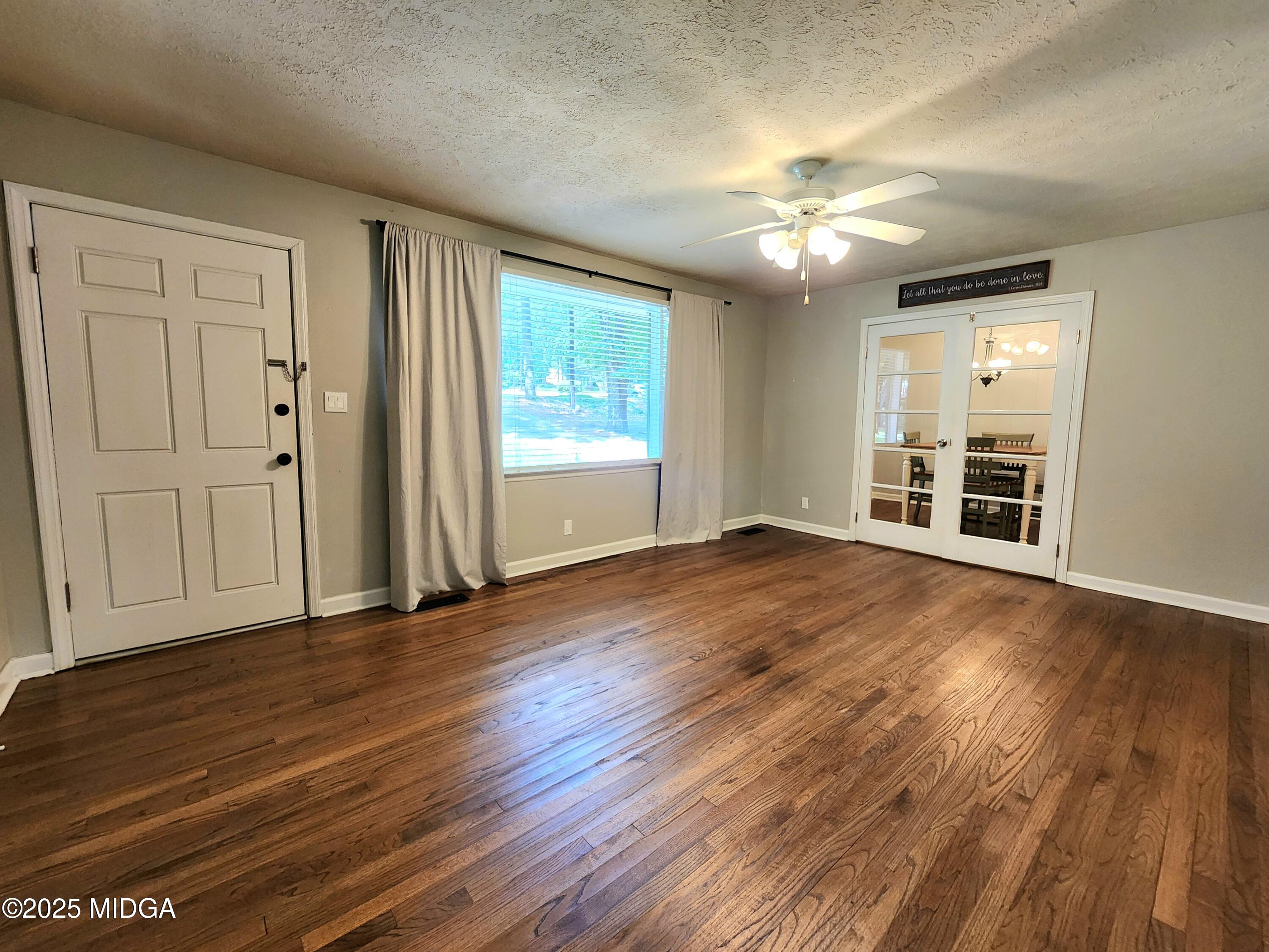 807 Wera Place Macon, GA 31210 - Photo 25 of 42 an empty room with wooden floor chandelier fan and windows