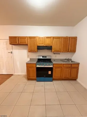 a kitchen with granite countertop a stove a sink and a refrigerator