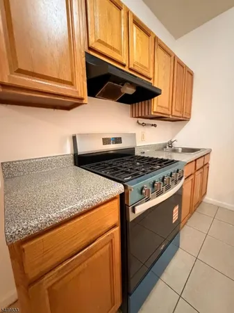 a kitchen with granite countertop cabinets and a stove top oven