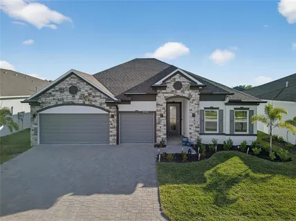a view of a house with a small yard and potted plants