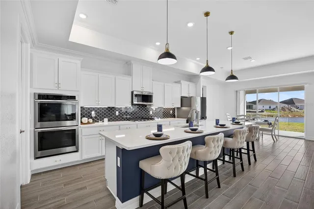 a kitchen with white cabinets and sink