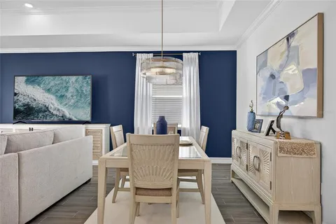 a view of a dining room with furniture a chandelier and wooden floor