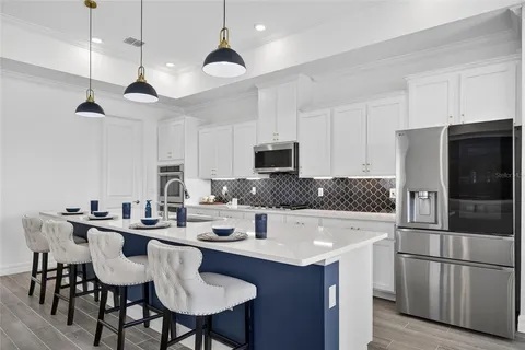 a open kitchen with stainless steel appliances granite countertop a stove a sink dishwasher a couches chairs and couches with wooden floor