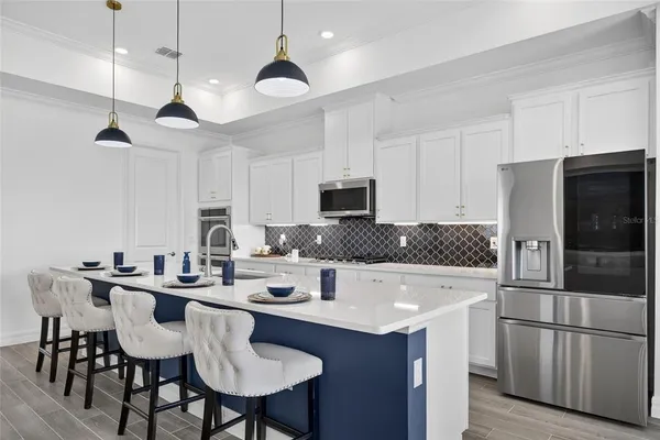 a open kitchen with stainless steel appliances granite countertop a stove a sink dishwasher a couches chairs and couches with wooden floor
