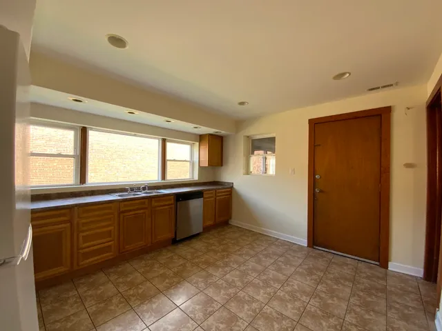 a large kitchen with granite countertop a sink and cabinets