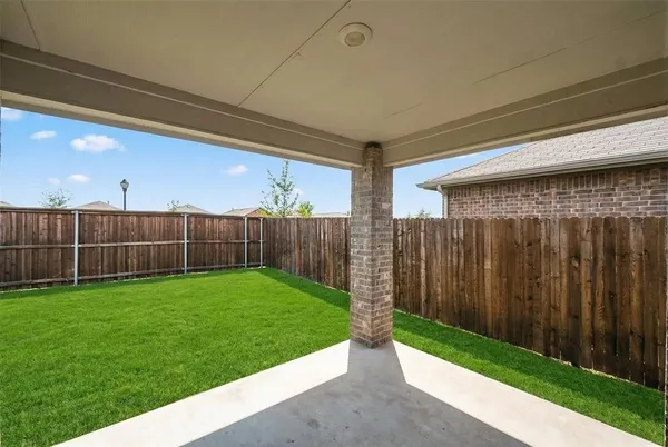 a view of a backyard with wooden fence