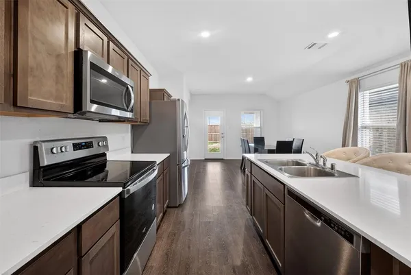 a kitchen with stainless steel appliances granite countertop a sink stove and refrigerator