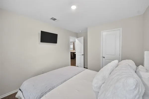 a bedroom with a bed and a flat screen tv