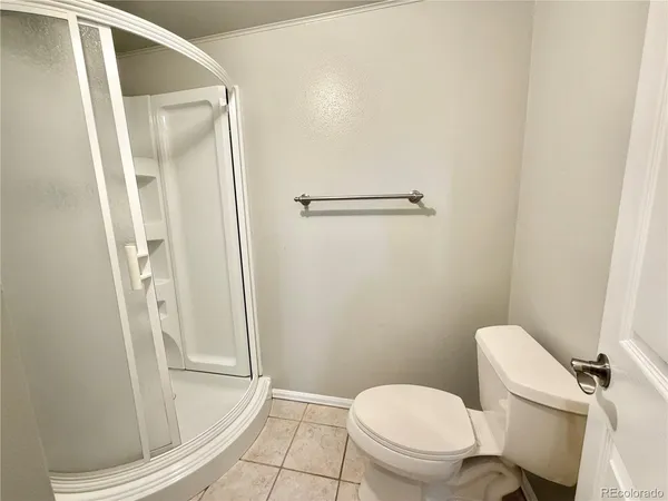 a white toilet sitting next to a shower