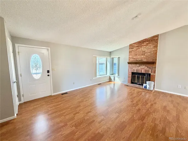 wooden floor fireplace and windows in an empty room