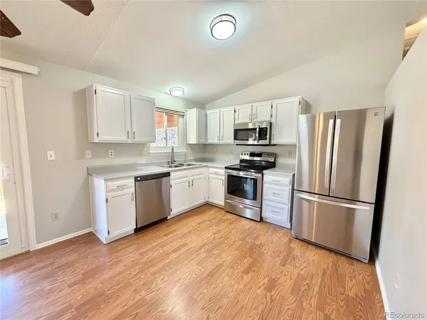 a kitchen with a refrigerator a stove top oven and stainless steel appliances