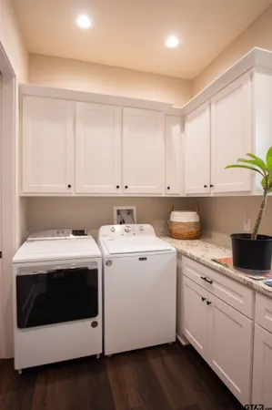 a utility room with cabinets washer and dryer