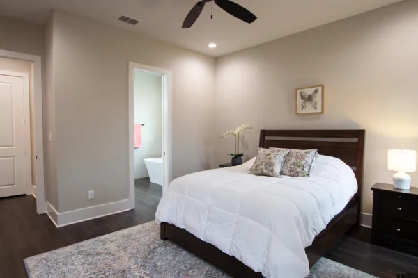 a bedroom with a bed and wooden floor