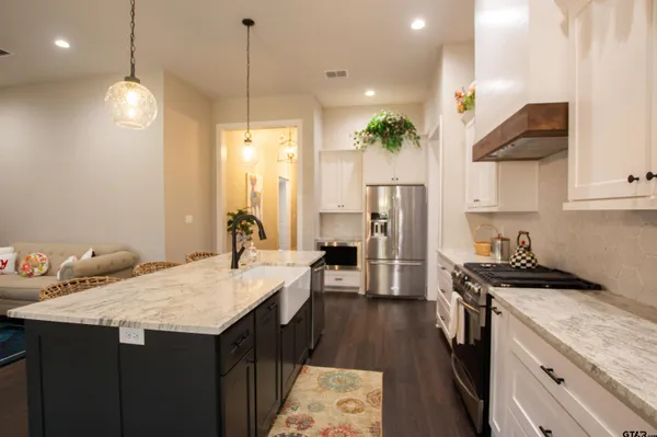 a kitchen with a sink a stove a refrigerator and cabinets