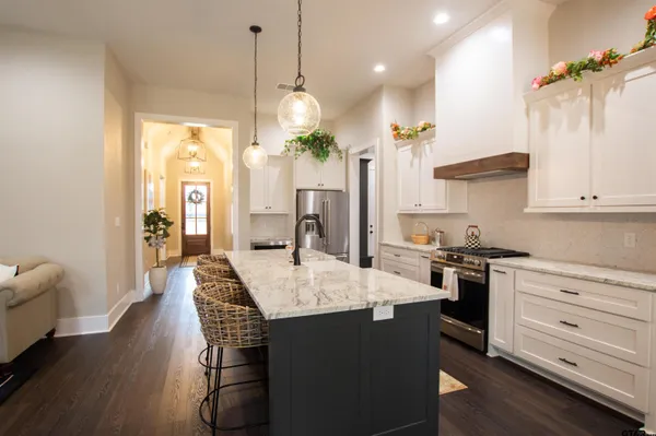 a kitchen with a table chairs stove and wooden floor