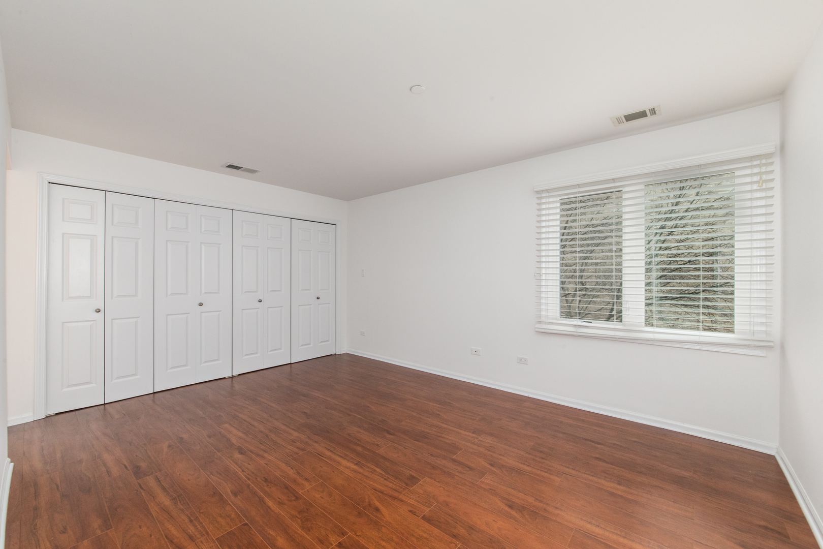 2021 Ammer Ridge Court, Unit 202 Glenview, IL 60025 - Photo 12 of 24 a view of an empty room with wooden floor and a window