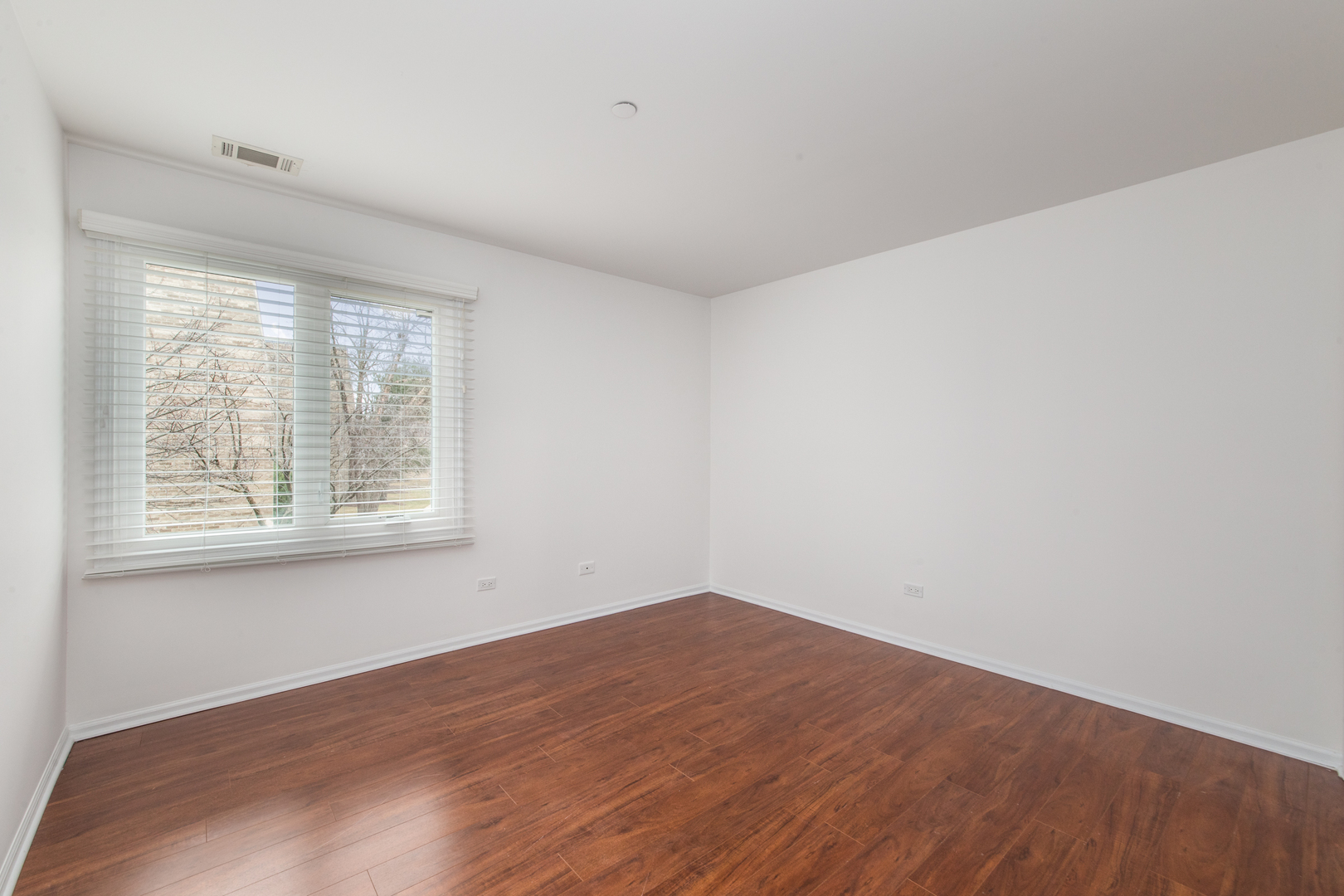 2021 Ammer Ridge Court, Unit 202 Glenview, IL 60025 - Photo 17 of 24 a view of empty room with wooden floor and fan