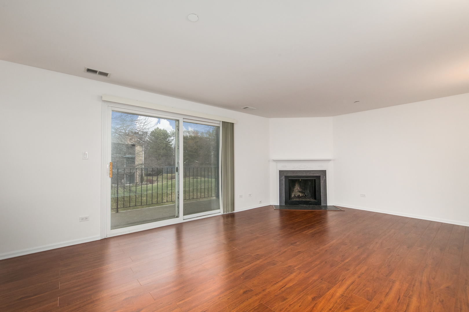 2021 Ammer Ridge Court, Unit 202 Glenview, IL 60025 - Photo 3 of 24 a view of an empty room with wooden floor and a window
