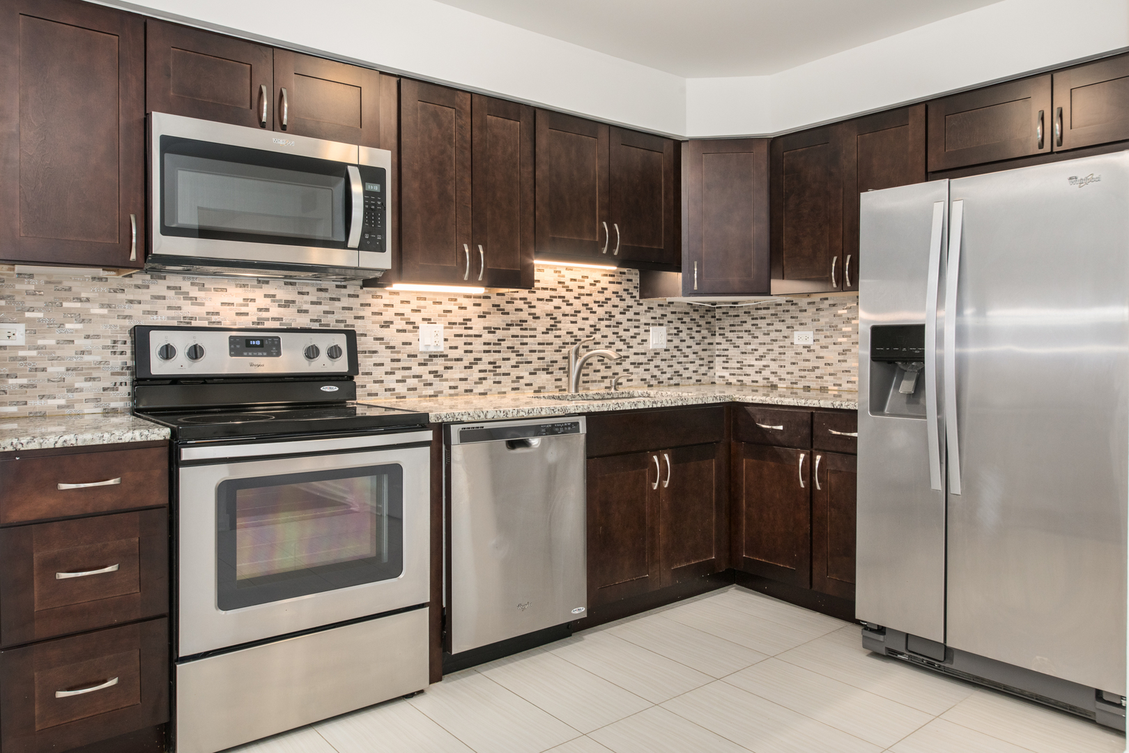 2021 Ammer Ridge Court, Unit 202 Glenview, IL 60025 - Photo 5 of 24 a kitchen with granite countertop wooden cabinets a refrigerator and a stove